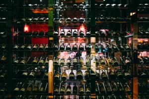 A shelf with various racks storing alcohol bottles, including wines, in a store.